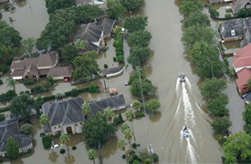 Boats traveling down a flooded street as a result of Hurricane Harvey.