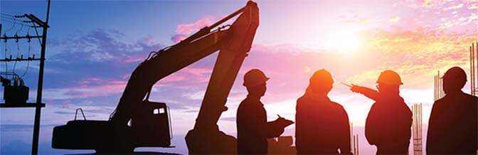 silhouette of construction workers next to tractor at sunset