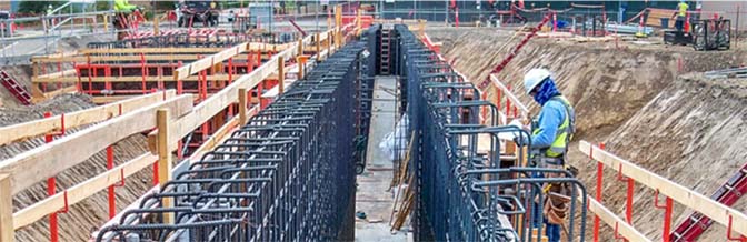 Construction worker setting rebar for a very large footing