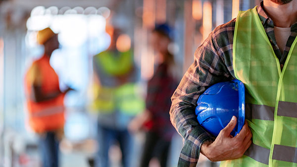 construction man holding hardhat under arm